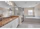 Bathroom featuring granite countertops, tile floors, a large mirror, soaking tub, and separate glass enclosed shower at 5724 Shell Ridge Dr, Lithia, FL 33547