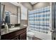Bathroom with granite vanity, a toilet, and a blue patterned shower curtain at 5724 Shell Ridge Dr, Lithia, FL 33547