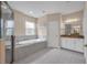 Spacious bathroom with a soaking tub, walk-in shower, granite countertops, and bright lighting for a spa-like experience at 5724 Shell Ridge Dr, Lithia, FL 33547