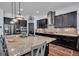 Gourmet kitchen featuring a large island, stainless steel appliances, dark cabinets, and stylish countertops at 5724 Shell Ridge Dr, Lithia, FL 33547
