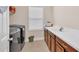 Well-equipped laundry room featuring modern washer and dryer, ample counter space, and storage at 5724 Shell Ridge Dr, Lithia, FL 33547