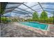 Outdoor pool area with a hammock, lounge chairs, and a screened enclosure at 5724 Shell Ridge Dr, Lithia, FL 33547