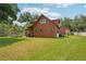 A rustic cabin-style home featuring a spacious lawn and charming detached garage at 5817 Myrtle Ln, Tampa, FL 33625