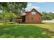Rustic cabin-style home featuring a spacious lawn and covered deck, perfect for outdoor living at 5817 Myrtle Ln, Tampa, FL 33625