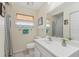 Bright bathroom featuring a white vanity, decorative mirror, and tiled floor at 5817 Myrtle Ln, Tampa, FL 33625