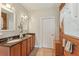Bathroom features dual sinks with granite counters, wood accent wall, and tile floors at 5817 Myrtle Ln, Tampa, FL 33625