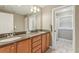 Bathroom with double sinks, wood cabinets, granite countertops, and a tile floor at 5817 Myrtle Ln, Tampa, FL 33625