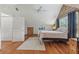 View of the bedroom with wood-paneled walls, a bed, a ceiling fan, and wood floors at 5817 Myrtle Ln, Tampa, FL 33625