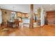 Open concept kitchen and dining area with beautiful wood flooring, a rustic support beam, and plenty of space at 5817 Myrtle Ln, Tampa, FL 33625