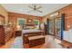 This primary bedroom features wood walls, exposed beams and natural light from the doors to the deck at 5817 Myrtle Ln, Tampa, FL 33625