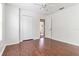 Bright bedroom with hardwood floors, open doorway and a ceiling fan at 5839 Meadowpark Pl, Lithia, FL 33547