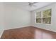 Well lit bedroom with hardwood floors, large window and a ceiling fan at 5839 Meadowpark Pl, Lithia, FL 33547