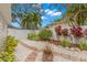 A serene backyard with a brick pathway, white gravel, lush plants, and a charming fountain at 626 16Th Ne Ave, St Petersburg, FL 33704