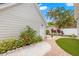 Beautifully landscaped backyard featuring a brick pathway, white gravel, vibrant plants, and artificial turf at 626 16Th Ne Ave, St Petersburg, FL 33704