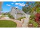 Beautiful backyard featuring brick pathway, lush landscaping, and charming exterior details at 626 16Th Ne Ave, St Petersburg, FL 33704