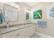 Bright bathroom featuring double sinks with modern fixtures, framed mirrors, and a large window at 626 16Th Ne Ave, St Petersburg, FL 33704