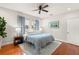 Bright bedroom featuring hardwood floors, a ceiling fan, and windows with elegant blue curtains at 626 16Th Ne Ave, St Petersburg, FL 33704