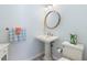 Cozy half bath with pedestal sink, hardwood floors, charming mirror and coastal decor at 626 16Th Ne Ave, St Petersburg, FL 33704