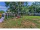 Large backyard featuring a swing set, grassy area, and mature trees, perfect for Gathering fun at 629 Lexington St, Dunedin, FL 34698