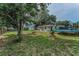 Large backyard with mature trees, storage shed, swingset, and trampoline at 629 Lexington St, Dunedin, FL 34698
