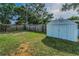 Fully fenced backyard with a storage shed and ample grassy area, providing both security and space at 629 Lexington St, Dunedin, FL 34698
