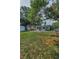 Spacious backyard with mature trees, a swing set, and plenty of room for outdoor activities at 629 Lexington St, Dunedin, FL 34698