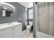 Neutral bathroom has white toilet and sink vanity combination with a shower and tub at 629 Lexington St, Dunedin, FL 34698