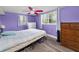 Bedroom features wood-look plank flooring, dual windows, and vibrant purple walls at 629 Lexington St, Dunedin, FL 34698