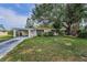 Charming single-story home with a well-manicured lawn and covered carport, shaded by mature trees at 629 Lexington St, Dunedin, FL 34698