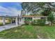 Inviting single-story home with covered parking, a well-kept lawn, and a mature shade tree at 629 Lexington St, Dunedin, FL 34698