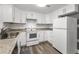 Bright kitchen featuring white cabinets, stone countertops, and modern appliances at 629 Lexington St, Dunedin, FL 34698