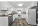 A bright kitchen showcases white cabinets, modern appliances, and stylish flooring for an appealing design at 629 Lexington St, Dunedin, FL 34698