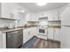 Modern kitchen featuring white cabinetry, stainless steel appliances, and ample counter space at 629 Lexington St, Dunedin, FL 34698