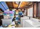 Rustic utility room with washer, dryer, storage shelves, and natural light from window at 629 Lexington St, Dunedin, FL 34698