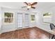 Bright sunroom has terra cotta tile, neutral curtains, and multiple windows at 629 Lexington St, Dunedin, FL 34698