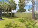 View of a well-maintained backyard featuring lush green grass and a sturdy fence and some Palm trees at 6820 Muncaster Ct, Tampa, FL 33625