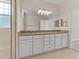 Primary bathroom with double granite vanity, white cabinets, and large mirror over the vanity at 6820 Muncaster Ct, Tampa, FL 33625