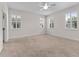 Spacious bedroom with neutral carpet, multiple windows with plantation shutters, and ceiling fan at 6820 Muncaster Ct, Tampa, FL 33625