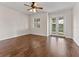 Bright room with hardwood flooring, ceiling fan, window with plantation shutters, and glass doors leading to backyard at 6820 Muncaster Ct, Tampa, FL 33625