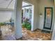 Charming brick courtyard with a welcoming 'Welcome' sign, green foliage, and metal table and chairs, perfect for relaxation at 6820 Muncaster Ct, Tampa, FL 33625