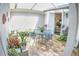 Outdoor dining area in the courtyard features a cozy seating arrangement with lush plants and an awning for shaded comfort at 6820 Muncaster Ct, Tampa, FL 33625