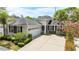 Beautifully landscaped home featuring lush greenery, a two-car garage, and a well-maintained exterior at 6820 Muncaster Ct, Tampa, FL 33625