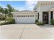 A well-maintained two-car garage with a concrete driveway and manicured landscaping around the exterior at 6820 Muncaster Ct, Tampa, FL 33625