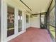 Covered lanai with red brick flooring, screened in window and double door access at 6820 Muncaster Ct, Tampa, FL 33625