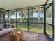 Screened-in lanai featuring tile floor, comfortable seating, and views of the lush backyard at 6820 Muncaster Ct, Tampa, FL 33625