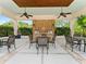 Outdoor grilling area with built-in brick grill, ceiling fans, and comfortable seating for gatherings at 6820 Muncaster Ct, Tampa, FL 33625