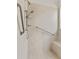 Accessible shower with grab bars, bench, hand-held shower head, and tiled walls and floor at 6820 Muncaster Ct, Tampa, FL 33625