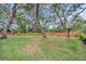 Spacious backyard with a wood fence and many mature trees at 714 1St Ct, Palm Harbor, FL 34684