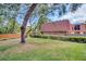Exterior view of home with a tile roof and fenced yard with mature trees at 714 1St Ct, Palm Harbor, FL 34684