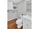 Charming half bathroom with floating shelves, white vanity, and tile flooring at 714 1St Ct, Palm Harbor, FL 34684